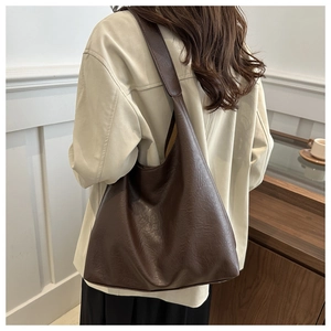 Close-up of deep brown soft PU leather tote with elegant pleated texture and shoulder strap