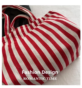 Close-up of red and white striped tote bag with herringbone weave and thick dual handles