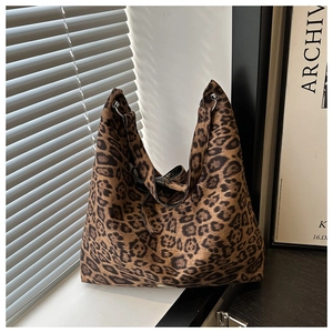 Detail of leopard print tote bag featuring silver metal rings and soft suede texture