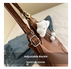 Detail of silver metal adjustable buckle on brown PU leather strap with cloud charm