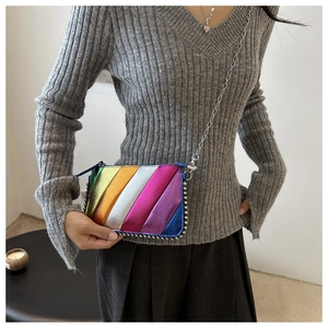 Rainbow metallic crossbody bag with silver studs and chain strap worn by a model