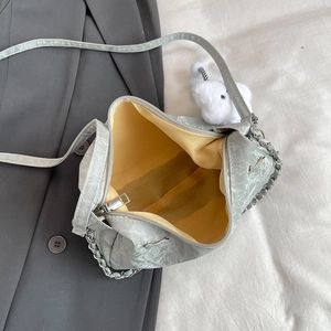 Silver metallic tote bag with yellow lining, chain strap and plush elephant charm