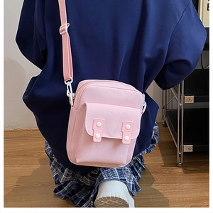 Détails du sac bandoulière rose en toile avec sangle réglable et boucle décorative