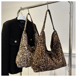 Detail of leopard print tote bags with drawstring bow on a minimalist display