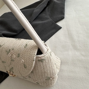 Straw shoulder bag with green floral lace embroidery and gold metal twist lock