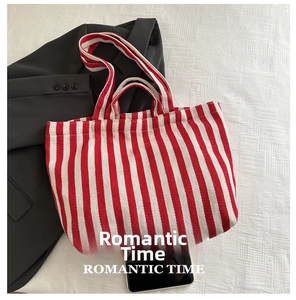 Detail of red and white striped canvas tote bag showing thick handles and woven texture