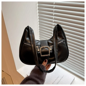 Detail of black PU leather underarm bag featuring silver buckles and double zipper accents