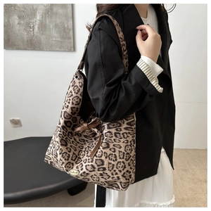 Dettaglio borsa shopper leopardata con fiocco marrone e placca in metallo dorato