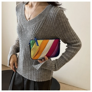 Detail of colorful metallic rainbow envelope bag with silver studs and thin chain strap