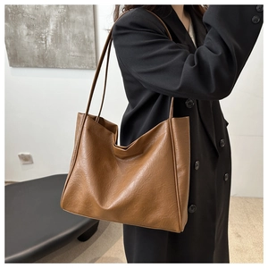 Détail du sac cabas marron caramel en cuir souple avec texture plissée et fini brillant
