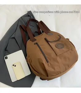 Brown nylon backpack with phone and iPad shown for size comparison reference