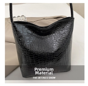 Close-up of black crocodile pattern leather texture on high-quality bucket bag