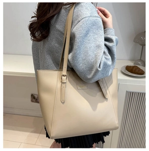 Detail of minimalist beige tote bag with adjustable shoulder straps and matte finish