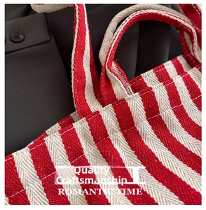 Close-up of red and white striped canvas tote bag with reinforced stitching details