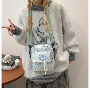 Détail du sac bandoulière vert menthe avec motifs de dessins animés et broderie STAR