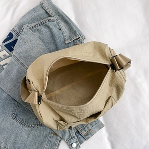 Large khaki nylon crossbody bag with wide shoulder strap and black zipper for daily commute