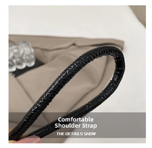 Close-up of black crocodile pattern leather shoulder strap with a glossy finish