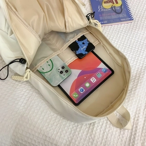 Cream nylon travel backpack showing spacious main compartment with tablet storage pockets