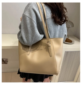 Close-up of minimalist large tote bag featuring beige leather texture and fashion patch