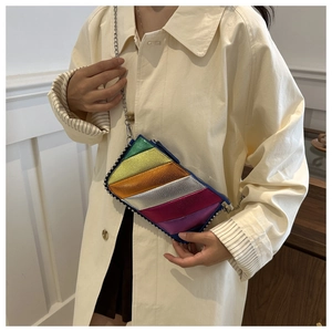 Detail of colorful metallic patchwork envelope bag with silver beaded trim and chain strap