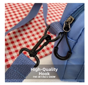 Detail of blue nylon bag with matte black metal swivel hook and U-pull zipper closure
