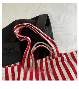 Macro view of red and white striped canvas tote with wide handle and fabric texture