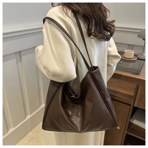 Détail de la texture en cuir PU marron doux et de la bandoulière d'un grand cabas