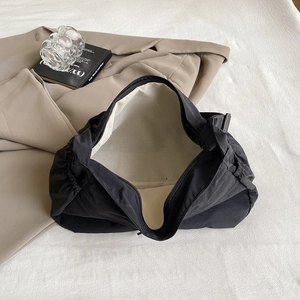Grand sac fourre-tout noir minimaliste en nylon avec doublure beige dans un décor de bureau