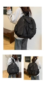 Detail shot of black high-capacity backpack with multi-pocket design and logo patch