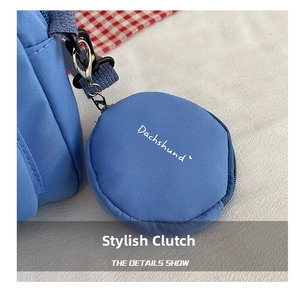 Detail of blue nylon round coin purse charm with metal clip on shoulder bag