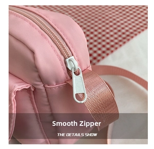 Detail show of smooth white plastic zipper and pink nylon shoulder strap on canvas bag