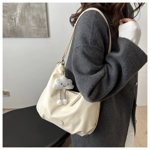 Detail of off-white pleated hobo shoulder bag with a cute cloud plush pendant charm
