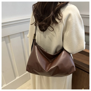 Detail of dark brown hobo bag showing supple leather texture and adjustable strap