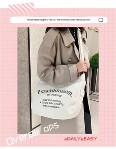 Close-up of white canvas crossbody bag featuring Peachblossom morning letter print