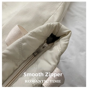 Close-up of smooth silver zipper and quilted diamond pattern on beige nylon tote bag