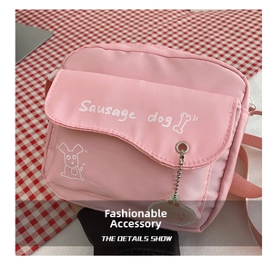 Detailed view of pink canvas crossbody bag with a cartoon sausage dog print on a checkered cloth