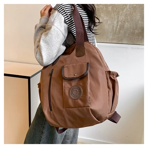 Detailed side view of brown backpack with multi-pocket design and adjustable straps