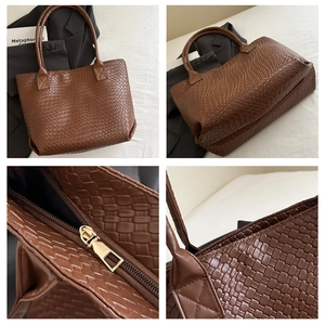 Detail of brown woven leather tote showing zipper closure and textured craftsmanship