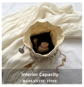 Detail view of pearl bucket bag interior with cosmetics, lace trim and gold chain strap