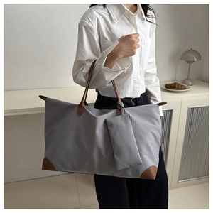 Waterproof grey nylon tote bag with leather accents and a small matching pouch detail