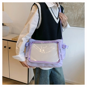 Detail view of purple canvas messenger bag with transparent front pocket and strap buckle
