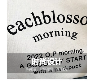 Detail of white canvas texture with bold black printed letters on a casual shoulder bag