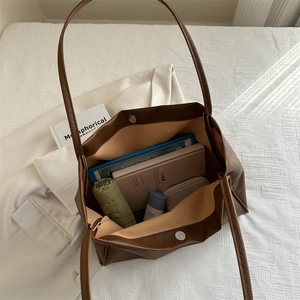 Grand sac cabas en cuir marron montrant l'espace intérieur pour ordinateur et accessoires