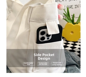 Detail showing side pocket of white canvas tote bag with a smartphone inside