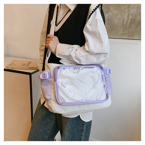 Close-up of white canvas messenger bag featuring a clear PVC front pocket and mesh detail
