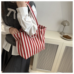 Detail of red and white striped canvas tote bag showing dual straps and thick texture