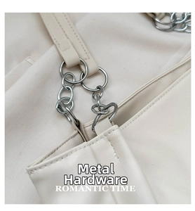 Detail of silver chain link and hardware on beige faux leather tote bag