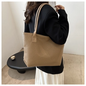 Side view of khaki woven tote bag showing large capacity and textured vegan leather material