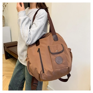 Brown nylon multi-pocket backpack tote with adjustable straps shown in lifestyle setting