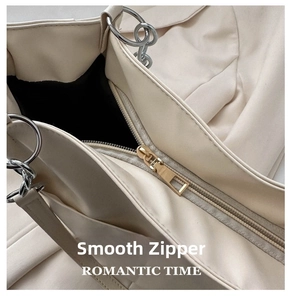Close-up of golden metal zipper and silver chain on vintage off-white leather tote bag